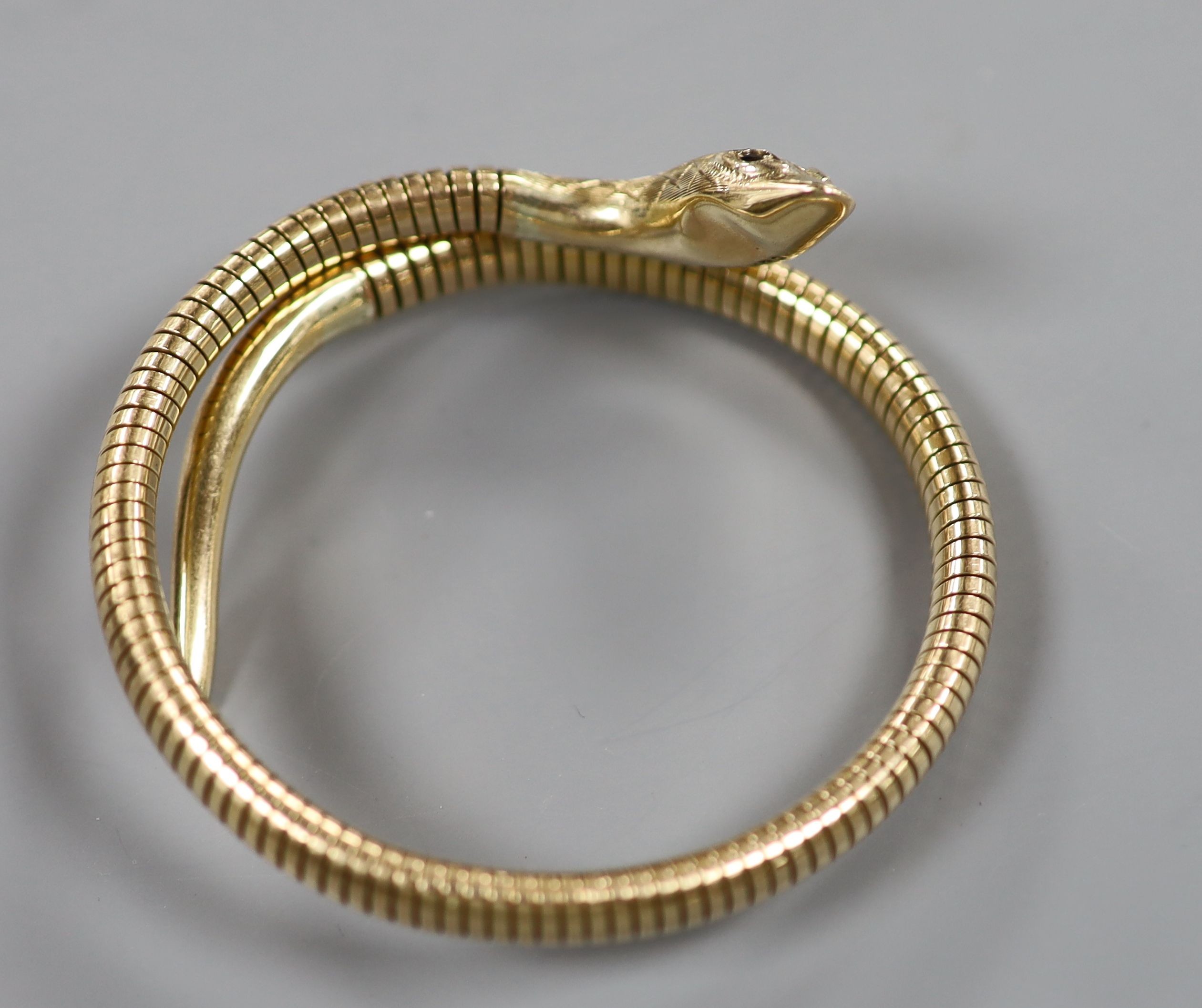 A mid 20th century 9ct gold coiled serpent bracelet, with gem set eyes, gross weight 22.4 grams (metal spring) (a.f.).